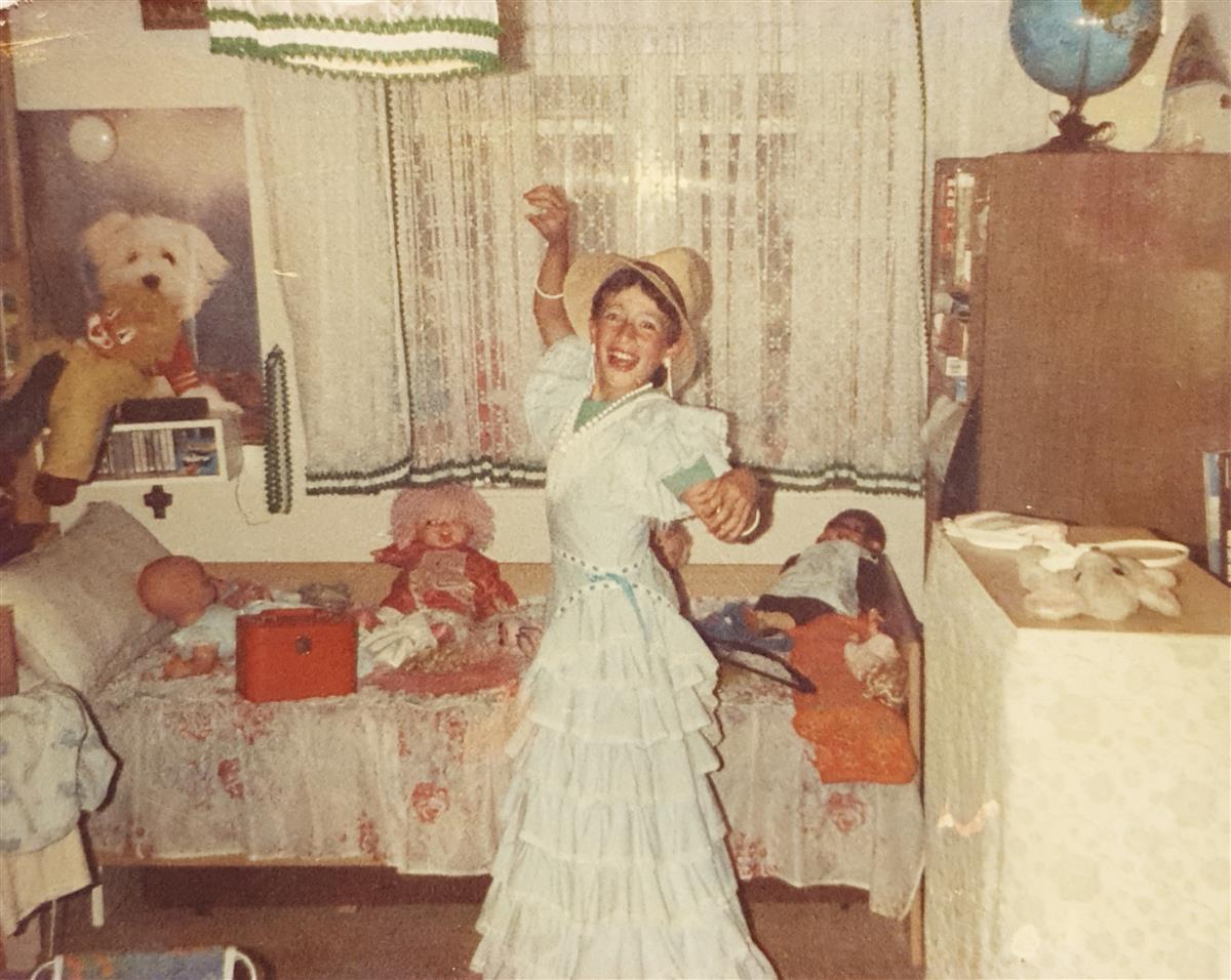 Junger Angel im Flamenco-Kleid seiner Cousine — lachend und tanzend
